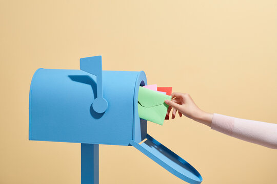 Person put or take out the letter by his hand in or out Mailbox.