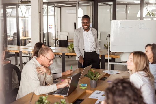 young businessman presents ideas in front of a group of workers
