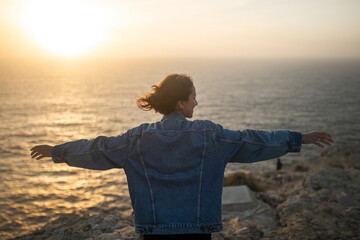 woman enjoying views on a cliff facing the sea