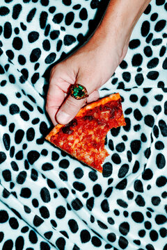 man with a bitten slice of pizza in his hand