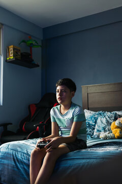Teenager at home playing video games.