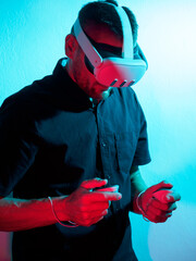 Multi coloured portrait of man wearing virtual reality headset with game controllers.