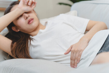 Obraz na płótnie Canvas person feeling stomach pain menstruation on the bed.