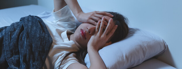 Asian women opened eyes lying on the bed have an insomnia problems.