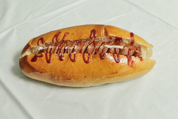 hot dog with ketchup on a white paper 