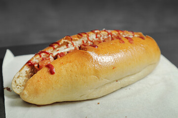 hot dog with ketchup on a white paper