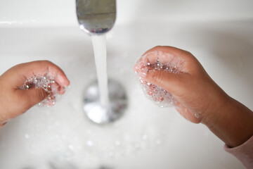 child washing hands with soap 