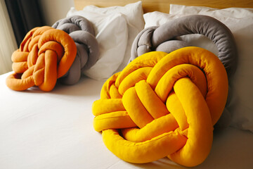 three knotted pillows are sitting on a bed