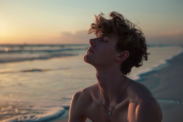 Fototapeta na wymiar A 20-year-old man in a yoga pose on a serene beach at sunrise.