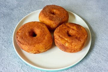 Sweet donuts with chocolate powder on a plate, close up