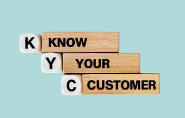 A stack of wooden blocks arranged in a tower that say word text acronym KYC KNOW YOUR CUSTOMER 