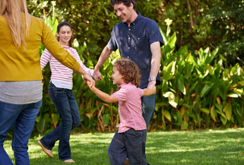 Happy family, holding hands and kids dance in nature or play game in summer together in circle at park. Ring a rosy, smile and children in garden on holiday, vacation or bonding with parents outdoor