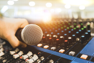 Hand sound engineer holding microphone on audio mixer in live broadcasting studio producer for sound record control system production and equipment and music instrument speaker.