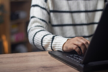 The young businessman, dressed in a thick long-sleeved jacket, was immersed in his work typing on...