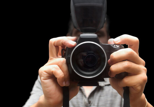 photographer self portrait , holding camera on black background,Concept taking himself through mirror
