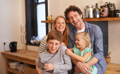 Family, portrait and hug in kitchen with happiness, love and security at home for bonding. Mother, father and children with laughter and playful together, people with smile and support with trust