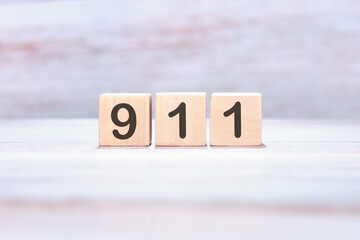 The number 911 on wooden cubes on a light background