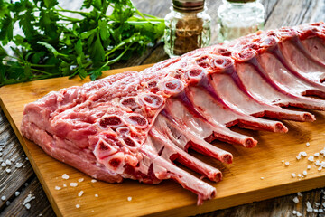 Raw veal ribs on cutting board on wooden table
