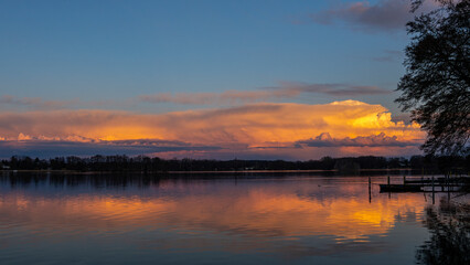 Leuchtende Wolken im Abendrot, Im Vordergrund ein See