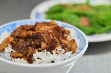 Photo of the Lu Rou Fan, a Taiwanese staple, piles savory braised pork (ground pork simmered in soy sauce and spices) over fluffy white rice. Often served with a side of veggies, a must-try!