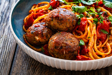 Spaghetti meatballs in tomato sauce on wooden table
