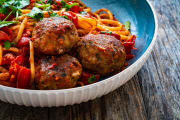 Spaghetti meatballs in tomato sauce on wooden table
