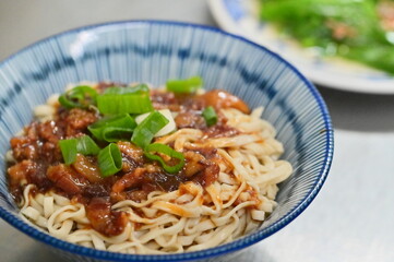 Photo of the Taiwanese Lu Rou Gan Mian features braised ground pork over smooth noodles (oil or ramen) with optional veggies. This savory comfort food is a must-try for any Taiwanese food adventure.