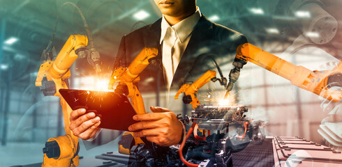 XAI Mechanized industry robot arm and factory worker double exposure. Concept of robotics technology for industrial revolution and automated manufacturing process.