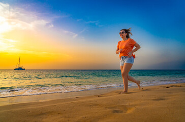 Beautiful mid-adult woman running on sunny beach