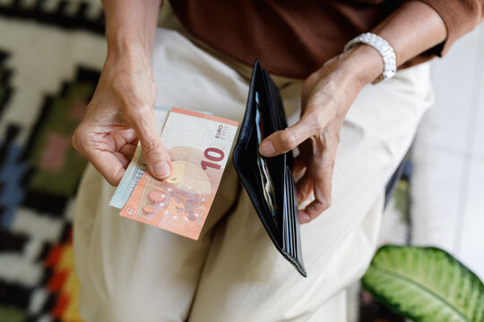 An anonymous woman holding a wallet and money