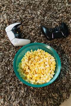 Video game controllers and a bowl of popcorn.