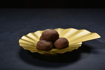 baked luxury dark chocolate coffee cocoa cookies with chocolate chip Himalaya rock salt and gold black plate gold fork knife on dark background pastry dessert halal vegan party food menu gluten free