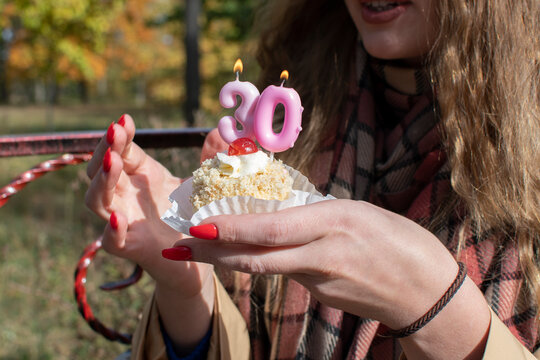 A birthday cupcake with pink 30th birthday numeral candle