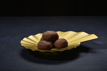 baked luxury dark chocolate coffee cocoa cookies with chocolate chip Himalaya rock salt and gold black plate gold fork knife on dark background pastry dessert halal vegan party food menu gluten free