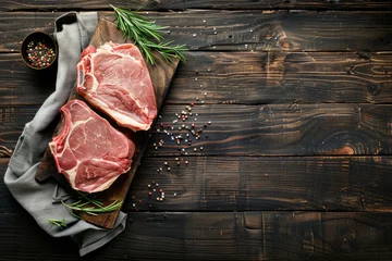 Fotobehang Two raw pork steaks placed on a wooden cutting board with assorted herbs and seasoning © Ilia Nesolenyi
