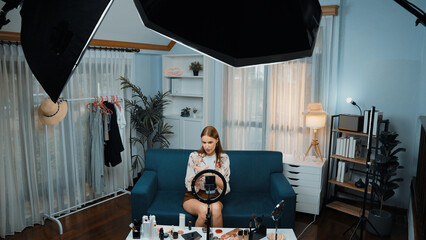 Fototapeta na wymiar Woman influencer shoot live streaming vlog video review makeup prim social media or blog. Happy young girl with cosmetics studio lighting for marketing recording session broadcasting online.