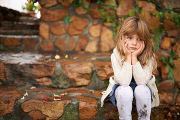 Thinking, sad and girl child in a garden bored, waiting or disappointed, unhappy or moody outside. Children, problem and frustrated kid in a park lonely, moody or upset outdoor with angry or tantrum