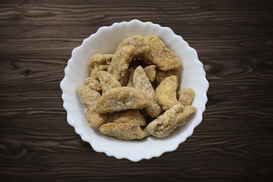 Sharkara chips madeup of Jaggery coating, Jaggery Coated Banana Chips sharkara varatti upperi with wooden background