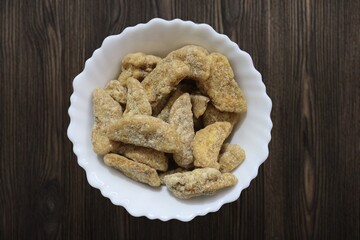 Sharkara chips madeup of Jaggery coating, Jaggery Coated Banana Chips sharkara varatti upperi with wooden background