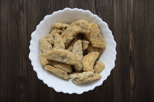 Sharkara chips madeup of Jaggery coating, Jaggery Coated Banana Chips sharkara varatti upperi with wooden background