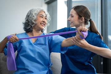 senior woman doing exercise at clinic with physiotherapist. help of a personal trainer during a rehabilitation session.