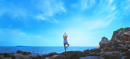 Asian women relax in the holiday. Travel relax.  Play if yoga. On the rocks by the sea. In the summer. Thailand - 759522173