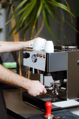 Zelfklevend Fotobehang a person using a coffee machine © DIAMOCK