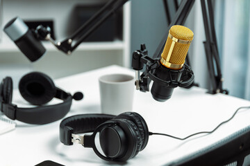 Modern office studio equipment microphone setting, laptop, tablet and headphone prepared with...