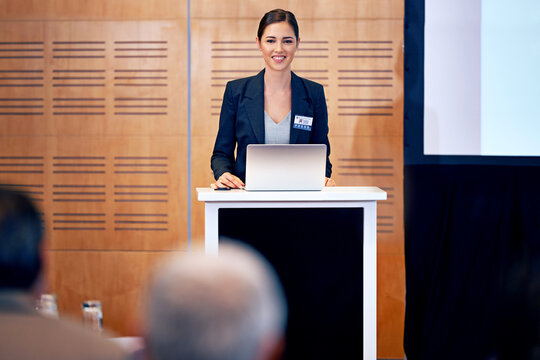 Business woman, podium and presentation with smile, conference or workshop with laptop for slideshow or PPT. Corporate training, seminar and speaker with info, audience and professional speech