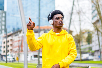 African young man in yellow clothes dancing listening to music