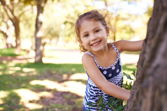 Young girl, child and portrait in park with games outdoor, playing in nature for childhood and fun with fresh air. Happiness, travel and freedom with youth, public garden or playground with smile