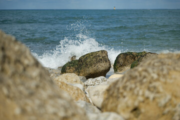 Vagues qui éclaboussent sur des rochers en bord de mer. 