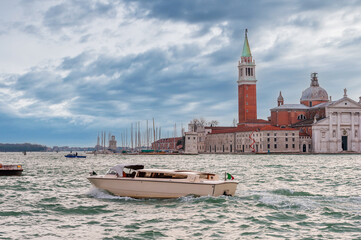 Water taxi in front of the island of San Giorgio Maggiore in the background in the Venice lagoon in Veneto, Italy - 759546940