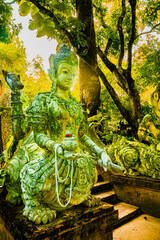 Ancient statue covered with moss in Wat Pha Lat